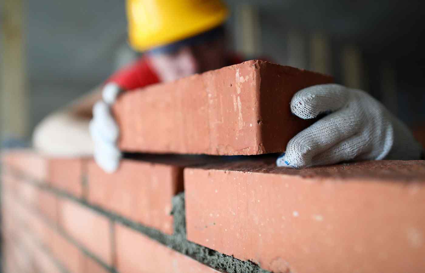 construction worker laying bricks of a new home