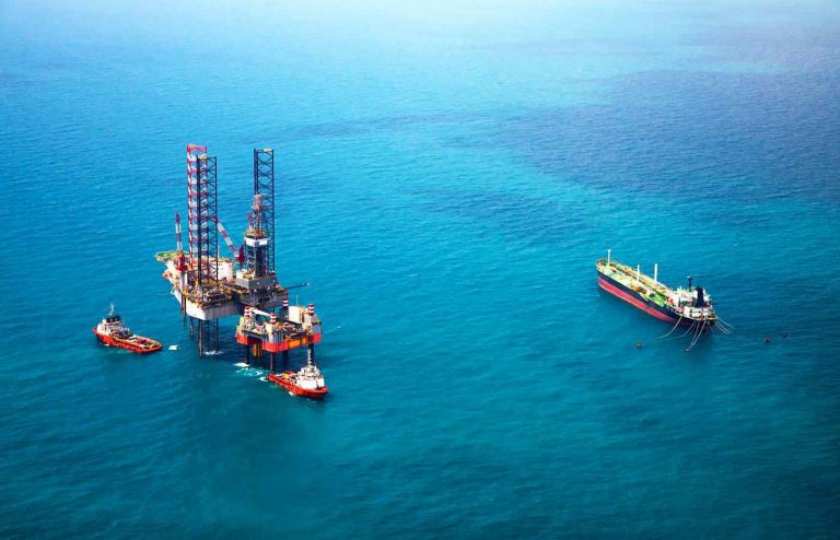 oil rig on the ocean delivering extracted materials onto boat