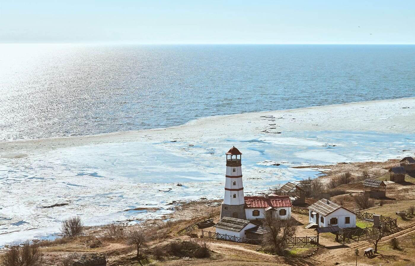 A lighthouse on the coast next to a beach