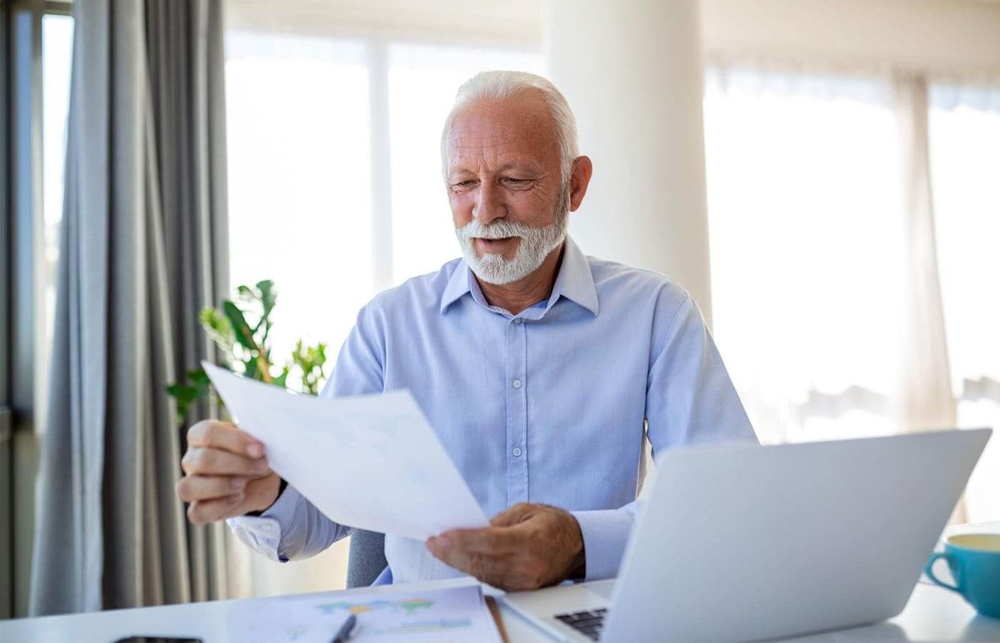 An elderly man looking at his investment portfolio