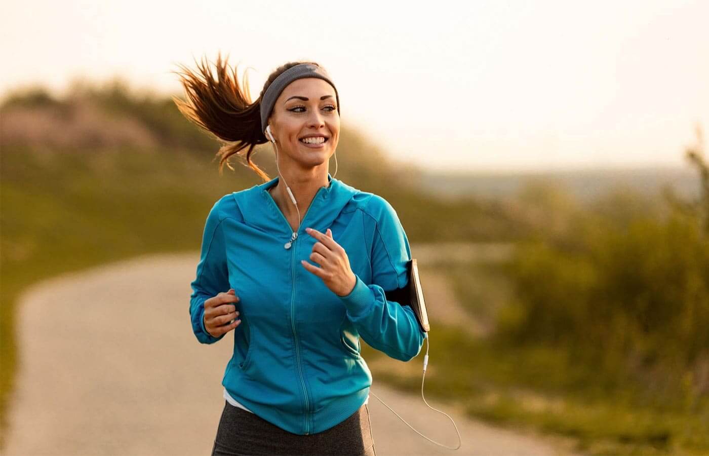 Young woman jogging along a road on a hill