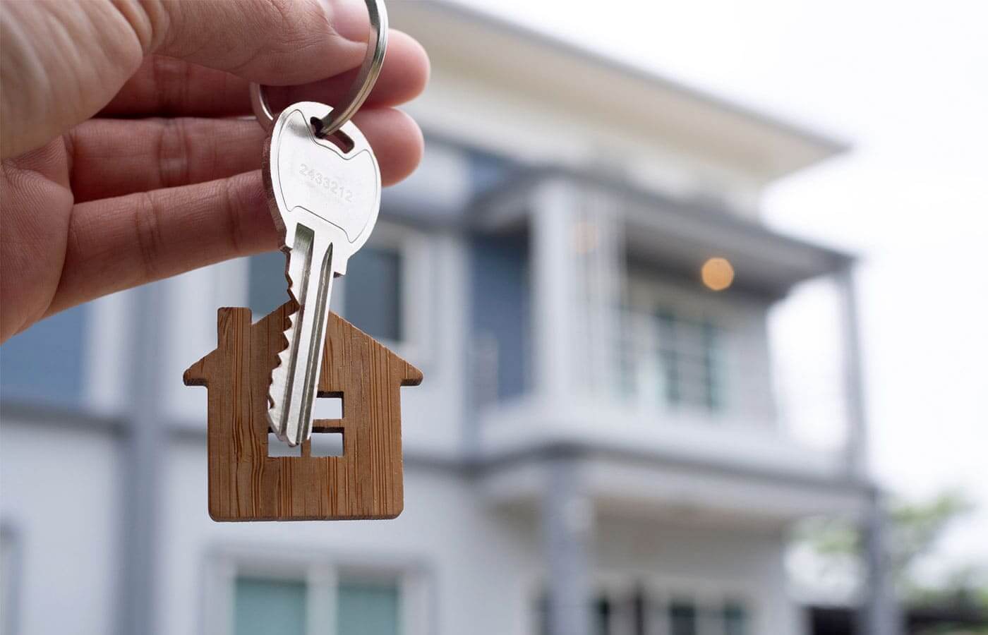 Landlord holding up keys in front of a new property