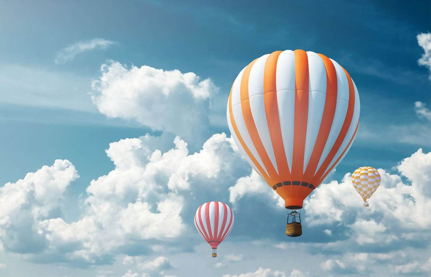Large hot air balloons traveling in a clear blue sky