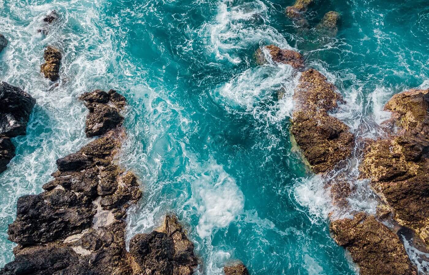 An ocean coastline with waves smashing against rocks