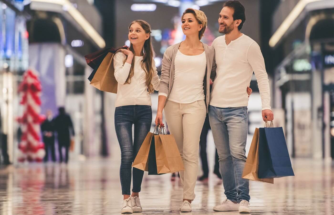 A young family walking though a shopping mall with shopping bags in hand