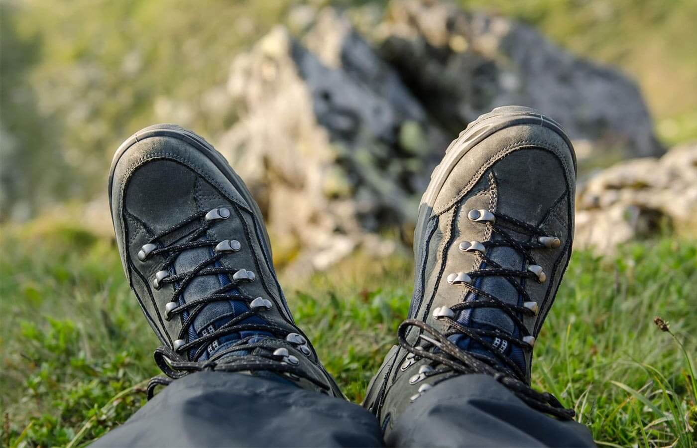 Man looking down at professional trekking boots in the mountains